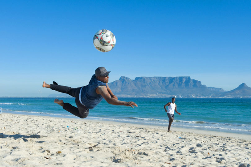 Young men playing football on the beach in Bloubergstrand,&lt;p&gt; Cape Town, South Africa